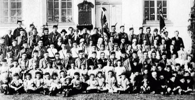 členstvo na záběru s pamětní deskou dvou bratří legionářů na fasádě původní sokolovny (zdroj: archiv obce Krmelín)