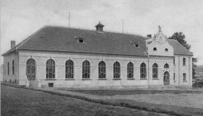 Původní vzhled sokolovny na dobové pohlednici (poslední stavení po pravé straně při výjezdu z Merklína na Staňkov)